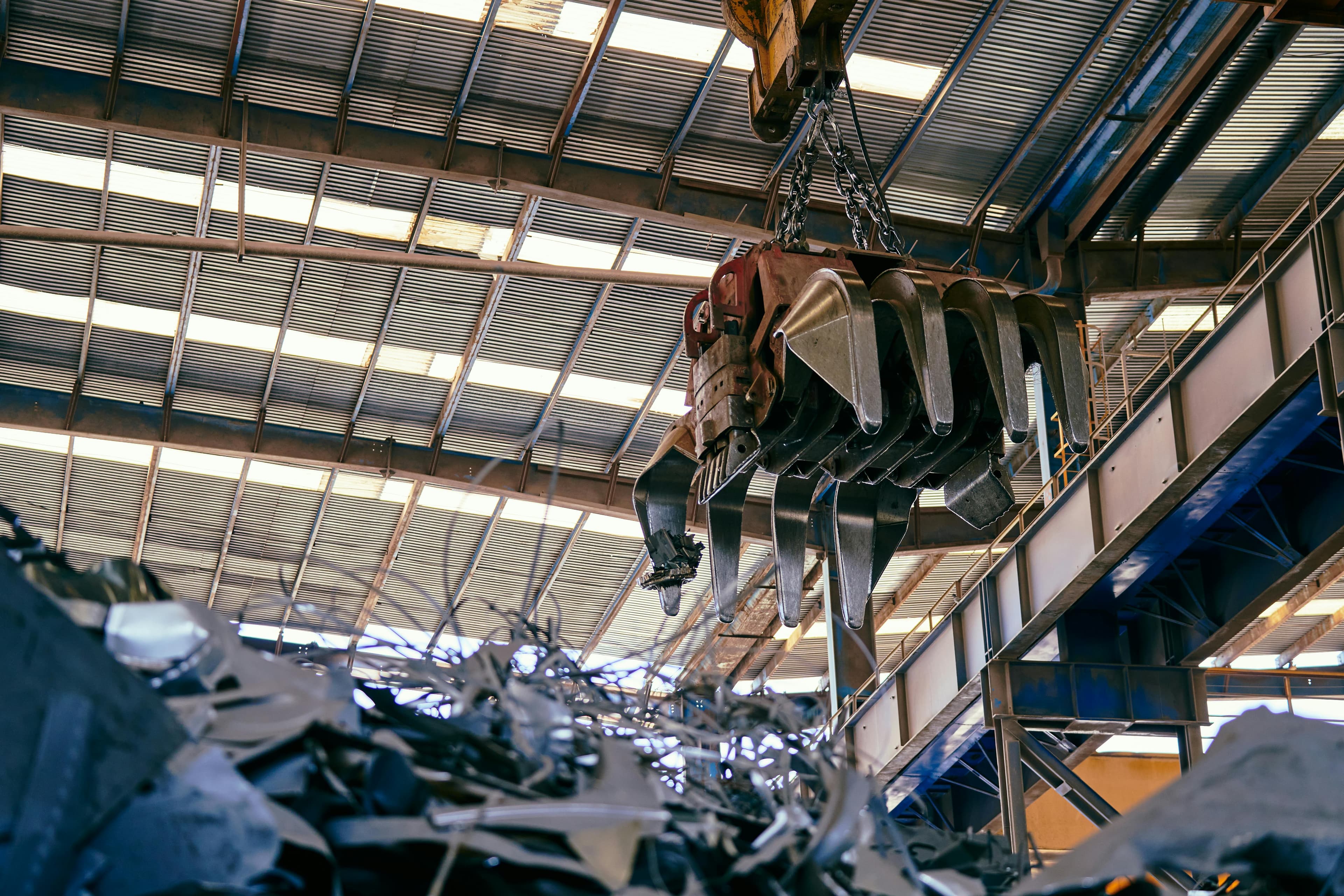 Grapple crane operating inside a certified scrap metal trading facility